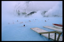 Iceland, Gullbringu, Blue Lagoon, Svartsengi power station with swimmers in thermal heated pool.