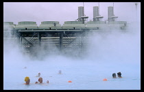Iceland, Gullbringu, Blue Lagoon, People bathing in the warm water beside the thermal powere station at Svartsengi.