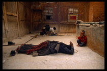 China, Ganzu, Xiahe Monastery, Tibetan ladies watched by a child prostrate themselves.