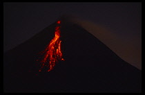 Indonesia, Java, Mount Merapi, The volcano erupting at night with lava flowing in streams down the side.