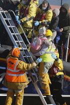 England, Kent, Dungeness, RNLI, helping migrants who have crossed the channel onto the beach.