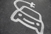 England, EV Charging station sign painted on road.