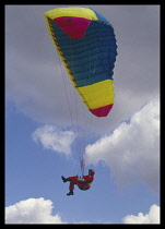SPORT, Air, Paragliding, Man suspended on harness below a parachute in the air above Devils Dyke in East Sussex England.