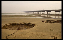 China, Zhengzhou, Dried bed of the Yellow river with bridge in the distance.