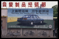 CHINA, Lanzhou, Volkswagen billboard advert with bikes parked underneath.