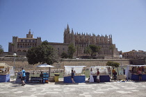 Spain, Balearic Islands, Majorca, Palma de Mallorca, Royal Palace of La Almudaina and La Seu Gothic Roman Catholic Cathedral of Santa Maria with market stalls in the foreground.