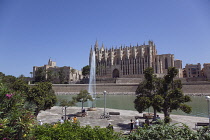 Spain, Balearic Islands, Majorca, Palma de Mallorca, Royal Palace of La Almudaina and La Seu Gothic Roman Catholic Cathedral of Santa Maria with fountain in the foreground.