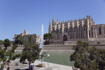 Spain, Balearic Islands, Majorca, Palma de Mallorca, Royal Palace of La Almudaina and La Seu Gothic Roman Catholic Cathedral of Santa Maria with fountain in the foreground.