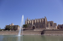 Spain, Balearic Islands, Majorca, Palma de Mallorca, Royal Palace of La Almudaina and La Seu Gothic Roman Catholic Cathedral of Santa Maria with fountain in the foreground.