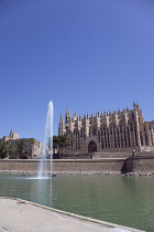 Spain, Balearic Islands, Majorca, Palma de Mallorca, Royal Palace of La Almudaina and La Seu Gothic Roman Catholic Cathedral of Santa Maria with fountain in the foreground.