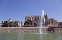 Spain, Balearic Islands, Majorca, Palma de Mallorca, Royal Palace of La Almudaina and La Seu Gothic Roman Catholic Cathedral of Santa Maria with fountain in the foreground.