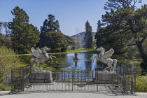 Ireland, County Wicklow, Enniskerry, Powerscourt Estate House and Gardens, The Winged Horses at the Triton Lake with fountain shooting into the air in the background.