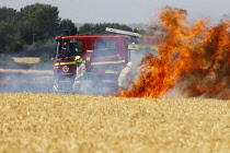 England, Kent, Fire Brigade attending fire in agricultural field with crop of grain on fire.