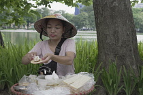 Vietnam, Hanoi, Street seller making a traditional Vietnamese sweet for sale.