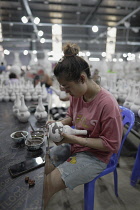 Vietnam, close to Hanoi, Ceramist painting a vase in a ceramic factory in Bat Trang ceramic village.