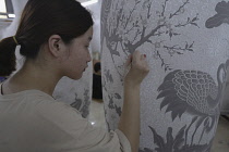 Vietnam, close to Hanoi, Ceramist painting a vase in a ceramic factory in Bat Trang ceramic village.