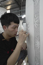 Vietnam, close to Hanoi, Ceramist painting a vase in a ceramic factory in Bat Trang ceramic village.