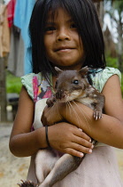 Colombia, Piraparana, San Miguel, Tukano girl with pet rodent.