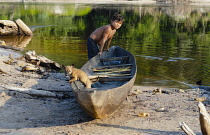 Colombia, Piaraparana, Tukano indian boy with dog.