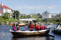 Norway, Lufoten islands, Group coming back from a boat trip in a traditional rowing boat close to village of Å.
