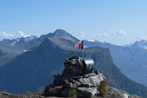 Norway-, Western Norway, Summit of Saksa mountain with Norwegian flag and Breidfonnhornet in the background. Sæbø.