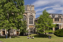 England, Oxfordshire, Oxford, Balliol College, Garden Quadrangle with students studying on the lawn and the college Dining Hall behind.