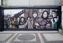 Ireland, North, Derry City, Murals depicting the original Derry Girls who worked in shirt making factories in The Craft Village within the old city walls.