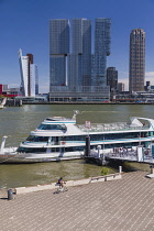 Holland, Rotterdam, The Nieuwe Maas River with the De Rotterdam Building in the centre flanked by the KPN Telecom Tower building on the left and the New Orleans Tower on the right with tourists disemb...