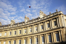 Exterior view of Royal Crescent with red hot air balloon in the blue sky with Cirrocumulus clouds.