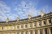 Exterior view of Royal Crescent with red hot air balloon in the blue sky with Cirrocumulus clouds.
