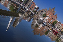 Holland, Rotterdam, Reflection of the double drawbridge known as the VOC Bridge across the Achterhaven with the Piet Hein Building named after a 16th century navigator born locally.