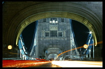 England, London, View along bridge illuminated at night with light trails from passing traffic.