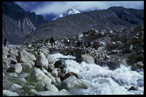 Afghanistan, General, Kirghiz men leading laden pack animals across stream in mountain landscape.