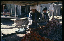 Afghanistan, Kandahar, Male vendors at roadside fruit and vegetable stall selling onions  potatoes and tomatoes.