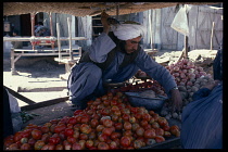 Afghanistan, Kandahar, Male vendor at roadside fruit and vegetable stall selling onions  potatoes and tomatoes.