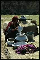 Afghanistan, General, Baluchi woman doing family laundry at well.