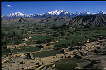 Afghanistan, Bamiyan, View over town buildings with mountains in the distance.