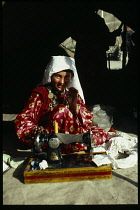 Afghanistan, General, Kirghiz woman using hand powered sewing machine.
