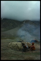 Afghanistan, General, Kirghiz nomad boy cooking on campsite.