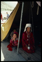 Afghanistan, General, Kirghiz nomad woman and children inside tent with spindle hanging from apex of roof.