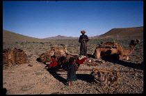 Afghanistan, General, Nomad family packing up and loading camel before moving on.