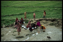 Afghanistan, General, Women and children washing pots in a puddle.