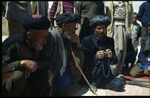 Afghanistan, Bamiyan Province, Yakawlang District, Khamestana Village.  Village elders in discussion  one man holding prayer beads.