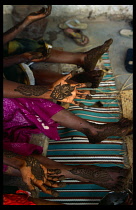SOMALIA, Baidoa, Cropped view of hands and feet of two women with designs painted in henna paste.