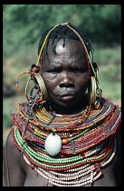 KENYA, People, Body Decoration, Pokot tribeswoman decorated with multiple bead necklaces and large hooped earrings.