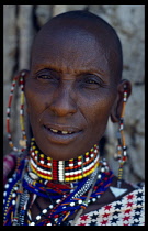KENYA, People, Body Decoration, Masai woman wearing multiple beaded necklaces and earrings .