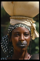 NIGER, People, Fulani woman with tatooed lips and gold nose ring through her septum.