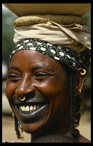 NIGER, People, Body Decoration, Smiling Fulani woman with tatooed lips and gold nose ring through her septum.