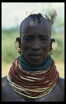 KENYA, Body Decoration, Turkana woman wearing mutiple beaded necklaces and earrings.