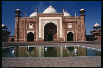 India, Uttar Pradesh, Agra, Exterior of mosque on the west side of the Taj Mahal with pool in the foreground.